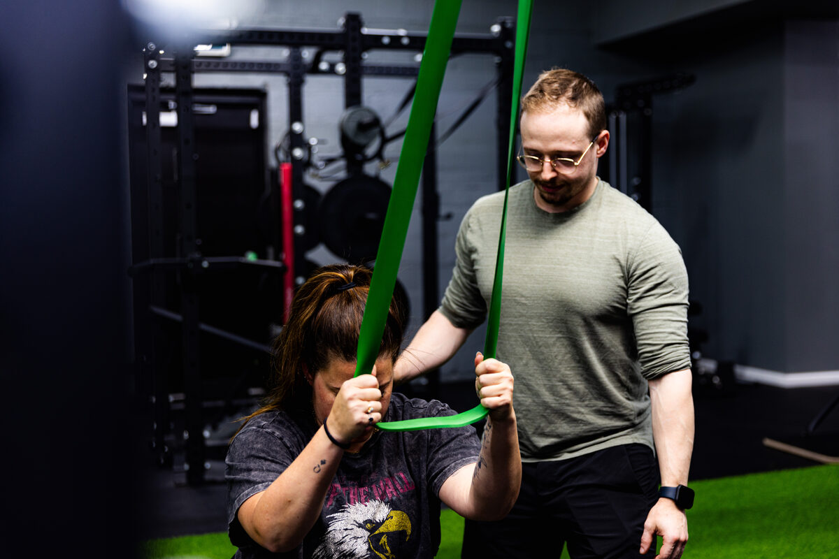 A member doing a guided resistance-band mobility exercise