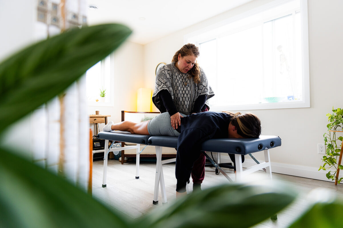 A practitioner guiding a member through gentle bodywork